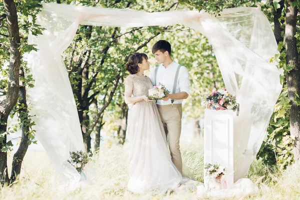 Casal de casamento na natureza. noiva e noivo com bolo no casamento . — Fotografia de Stock