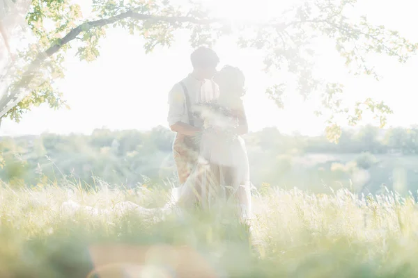 Весільна пара на природі. наречена і наречена обіймаються на сонці на весіллі . — стокове фото