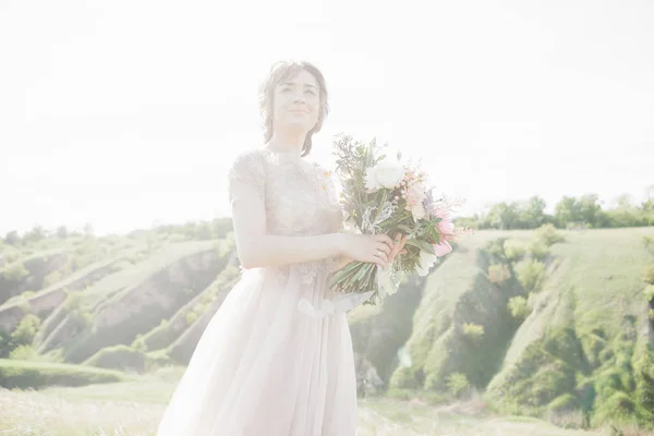 Portrait of beautiful bride with bouquet in nature. fine art photography.