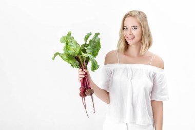 Güzel sarışın kadın pancar beyaz zemin üzerine yeşil yaprakları ile tutar. Sağlık ve vitaminler