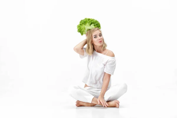 Beautiful blond woman in white blouse holding fresh green salad on white background. Health and Diet