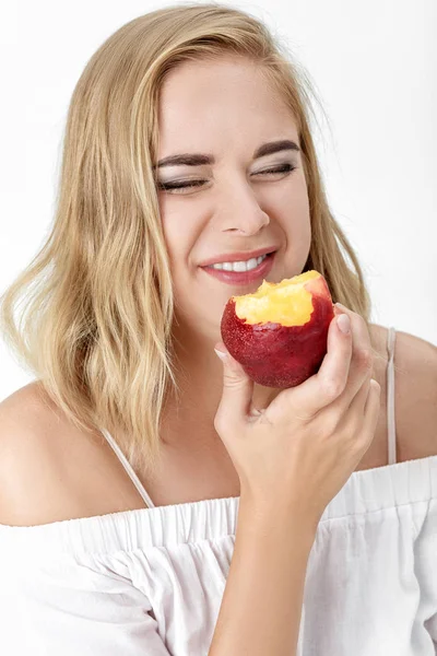 Piękne blond kobieta z przyjemności jedzenia nektarynka — Zdjęcie stockowe
