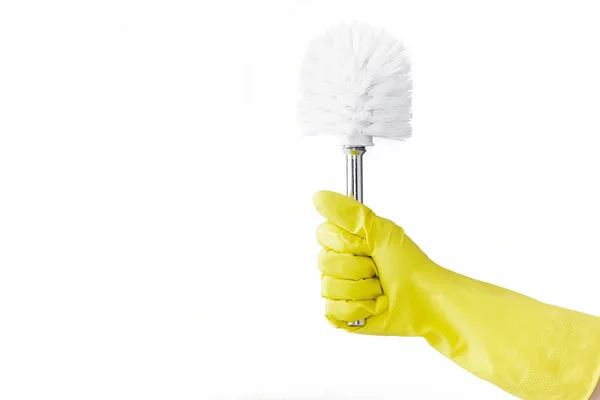 Mano in gomma gialla guanto tiene pennello per servizi igienici su sfondo bianco. pulizia . — Foto Stock