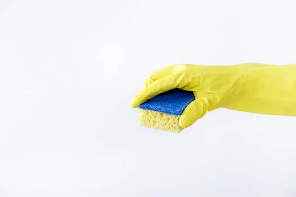 Hånd i gul hanske som holder svamp på hvit bakgrunn. rengjøring – stockfoto
