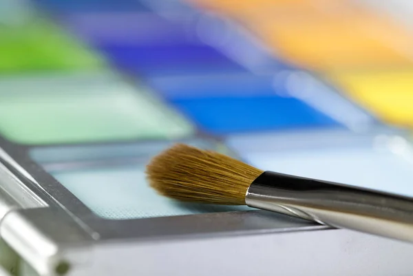 Palette of blue and yellow eye shadow and makeup brush — Stock Photo, Image