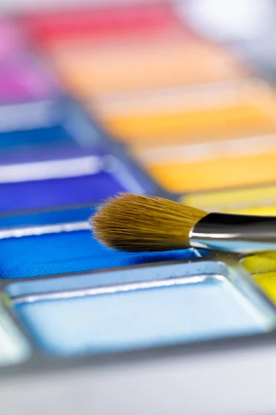 Palette of blue and yellow eye shadow and makeup brush — Stock Photo, Image