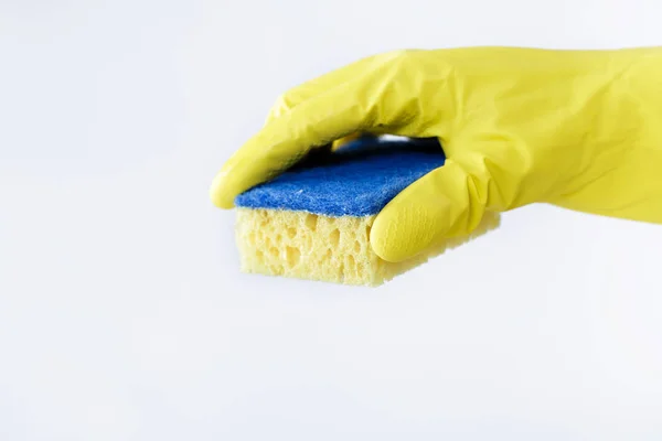 Mano in gomma gialla guanto tenendo spugna su sfondo bianco. pulizia — Foto Stock