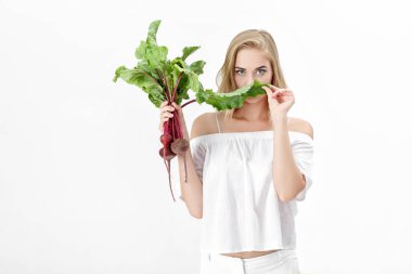 Güzel sarışın kadın pancar beyaz zemin üzerine yeşil yaprakları ile tutar. Sağlık ve vitaminler