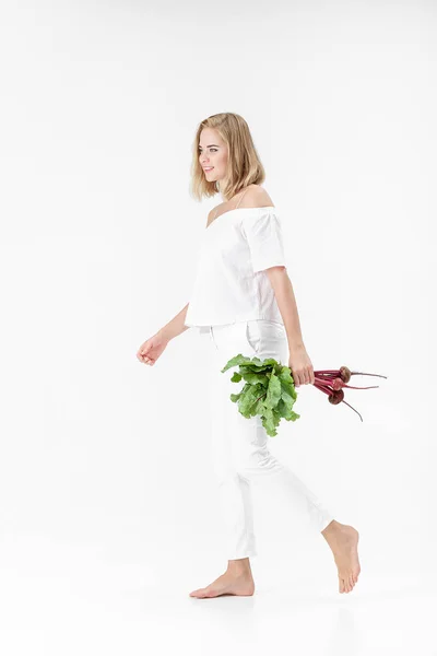 Schöne blonde Frau hält Rote Bete mit grünen Blättern auf weißem Hintergrund. Gesundheit und Vitamine — Stockfoto