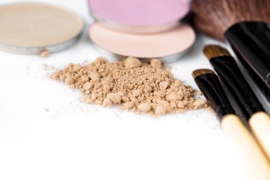 yüz, göz farı ve makyaj fırça beyaz zemin üzerine bej toz