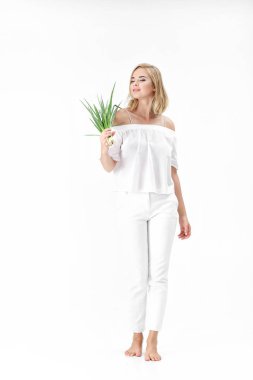 Beyaz bluz beyaz zemin üzerine yeşil soğan tutan güzel sarışın kadın. Sağlık ve vitaminler