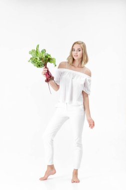 Güzel sarışın kadın pancar beyaz zemin üzerine yeşil yaprakları ile tutar. Sağlık ve vitaminler