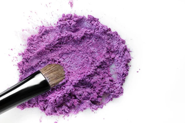 ezilmiş mor göz farı ve beyaz arka plan üzerinde izole makyaj fırça