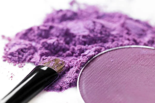 ezilmiş mor göz farı ve beyaz arka plan üzerinde izole makyaj fırça