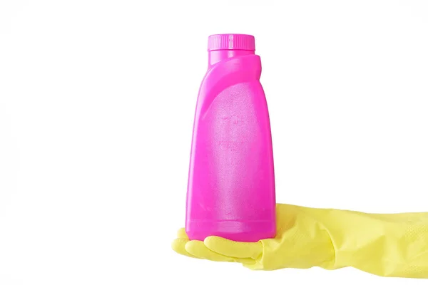 Hand in gele rubberen handschoen houdt roze fles bleekwater op witte achtergrond. reiniging — Stockfoto