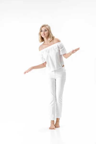 Όμορφη ευτυχισμένη ξανθιά γυναίκα σε λευκή μπλούζα και παντελόνι σε λευκό φόντο — Φωτογραφία Αρχείου