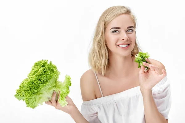 Belle femme blonde en chemisier blanc mangeant de la salade verte fraîche sur fond blanc. Santé et alimentation — Photo