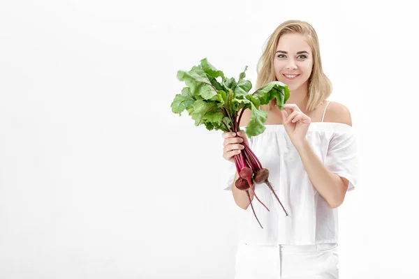 Beautiful blond woman holds beetroot with green leaves on white background. Health and vitamins — Stock Photo, Image