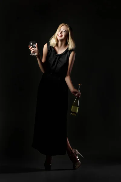 Szép részeg szőke nő fekete háttér fehér borosüveg tartó. Fél- és üdülési — Stock Fotó