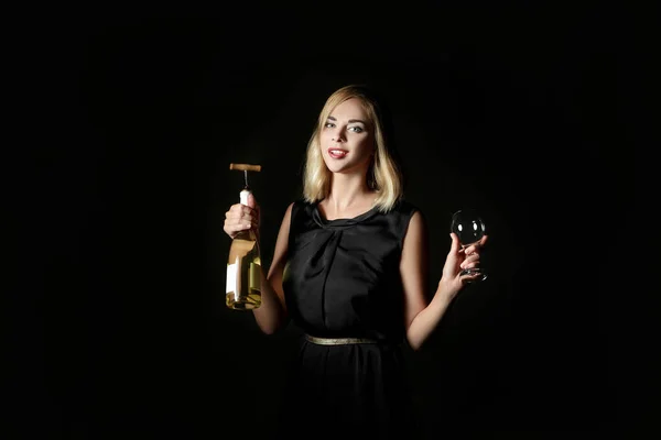 Beautiful blonde woman holding white wine bottle on black background. Party and holiday — Stock Photo, Image