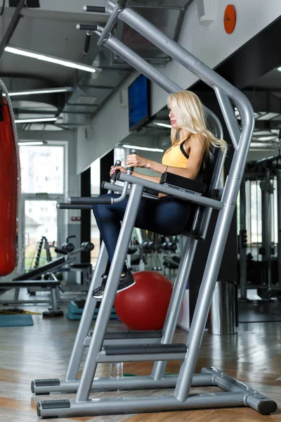 Αθλητική ξανθιά γυναίκα που χρησιμοποιούν μηχανή τύπου στο γυμναστήριο — Φωτογραφία Αρχείου