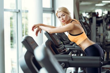 Çalışmadan sonra spor salonunda treadmill güzel yorgun sarışın kadın.