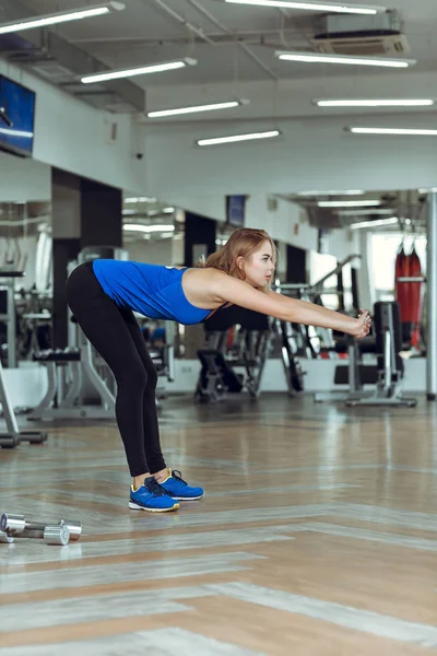 Ung smal blond kvinna göra övningar i gymmet — Stockfoto