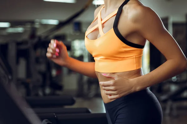 Athletische blonde Frau läuft im Fitnessstudio auf Laufband. — Stockfoto