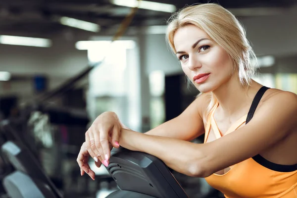 Vackra trött blond kvinna på löpbandet i gymmet efter träningspass. — Stockfoto