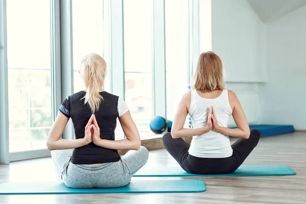 Two young women practicing yoga in gym. girl joining hands behind back — Stock Photo, Image