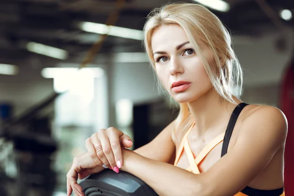 Vackra trött blond kvinna på löpbandet i gymmet efter träningspass. — Stockfoto