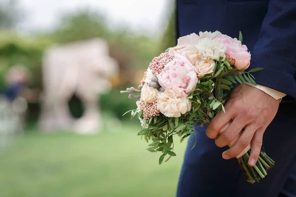 The groom holding a beautiful wedding bouquet of peonies — Stock Photo, Image