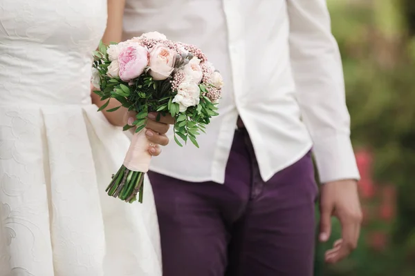 Наречений і наречений тримають весільний букет — стокове фото