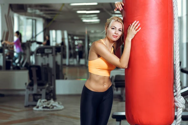 Втомлена молода жінка тренується з мішком після тренувань у спортзалі — стокове фото