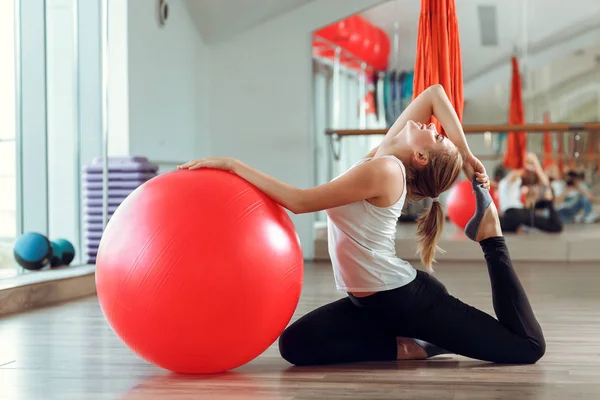 Ung atletisk kvinna gör övningar med fitness boll i gymmet — Stockfoto