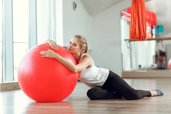 Νέα αθλητική γυναίκα κάνει ασκήσεις με μπάλα γυμναστικής στο γυμναστήριο — Φωτογραφία Αρχείου