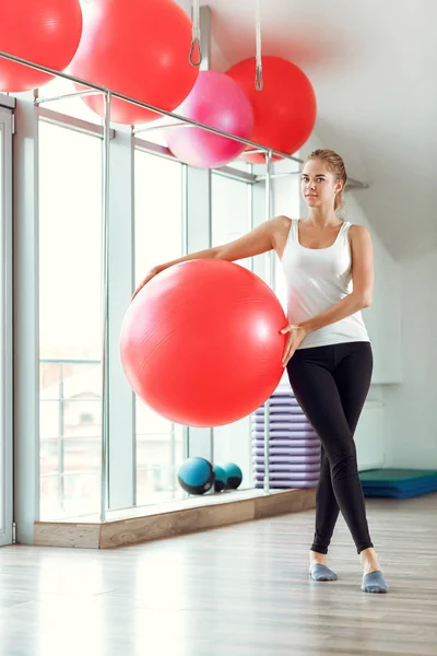 Νέα αθλητική γυναίκα κάνει ασκήσεις με μπάλα γυμναστικής στο γυμναστήριο — Φωτογραφία Αρχείου