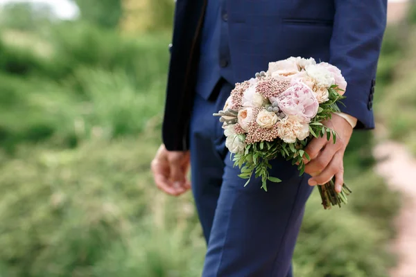 O noivo segurando um lindo buquê de casamento de peônias — Fotografia de Stock