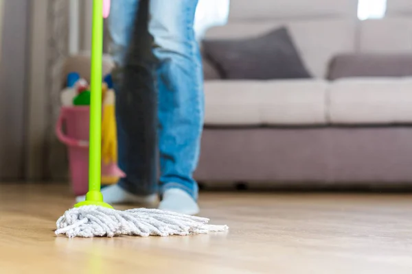 Woman in protective gloves using a wet-mop while cleaning floor — Stock Photo, Image