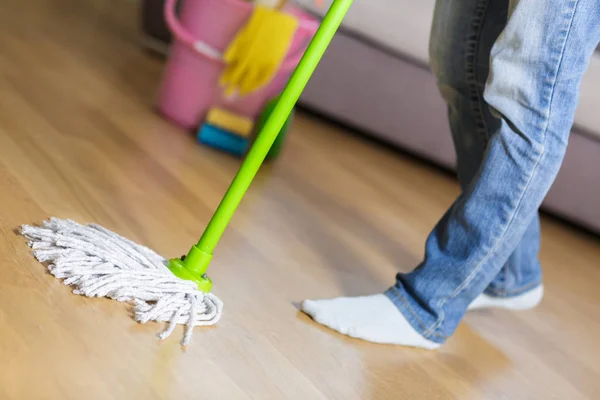 Vrouw in beschermende handschoenen met behulp van een NAT-mop tijdens het schoonmaken van de vloer — Stockfoto