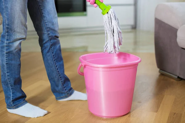 Vrouw in beschermende handschoenen met behulp van een NAT-mop tijdens het schoonmaken van de vloer — Stockfoto