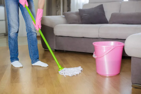 Woman in protective gloves using a wet-mop while cleaning floor — Stock Photo, Image