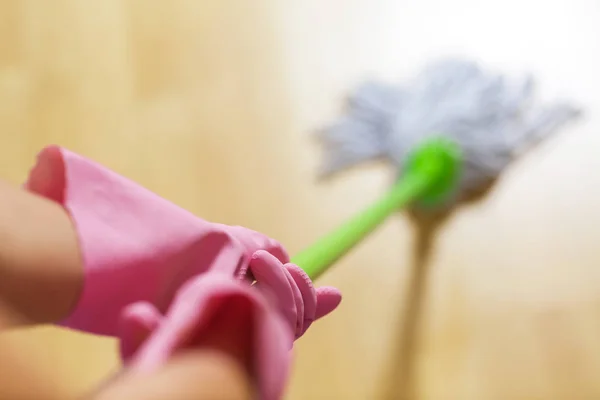 Vrouw in beschermende handschoenen met behulp van een NAT-mop tijdens het schoonmaken van de vloer — Stockfoto