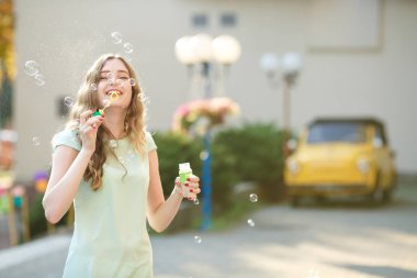 mutlu kadın sabun köpüğü üfleme. sabun köpüğü üzerinde odaklanmak