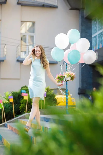 Bela mulher com voando balões multicoloridos — Fotografia de Stock