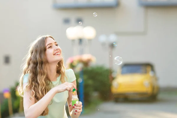 Šťastná žena fouká mýdlové bubliny — Stock fotografie