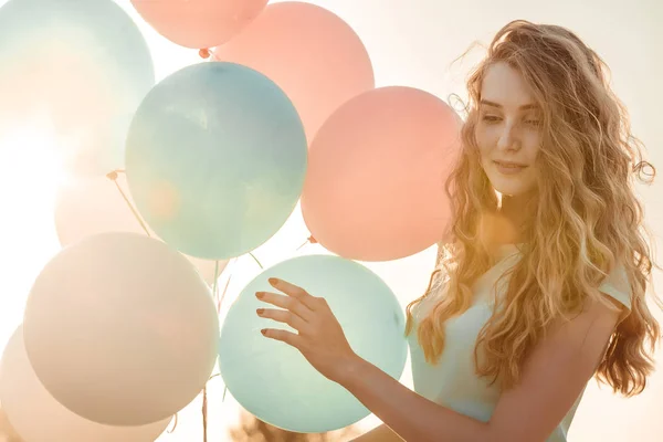 Vacker kvinna med flygande mångfärgade ballonger — Stockfoto