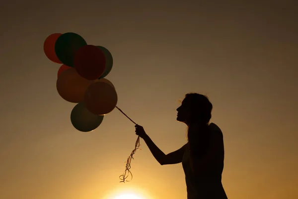 飞翔天空的气球的年轻女子的剪影. — 图库照片