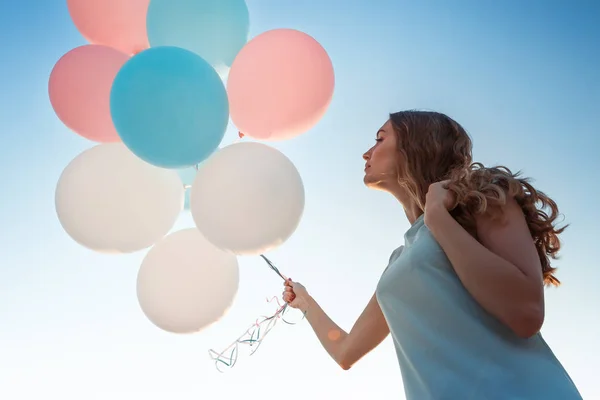 Vacker kvinna med flygande mångfärgade ballonger — Stockfoto