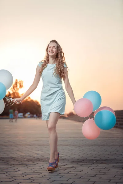 Hermosa mujer con vuelo multicolor globos — Foto de Stock